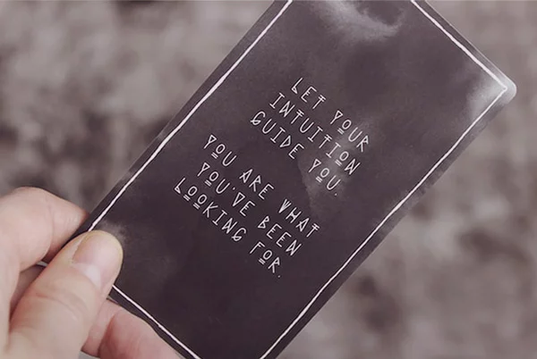 An image of a card with message “let your intuition guide you” on it. It symbolizes the metaphysical principles that explain how the Universe works. 